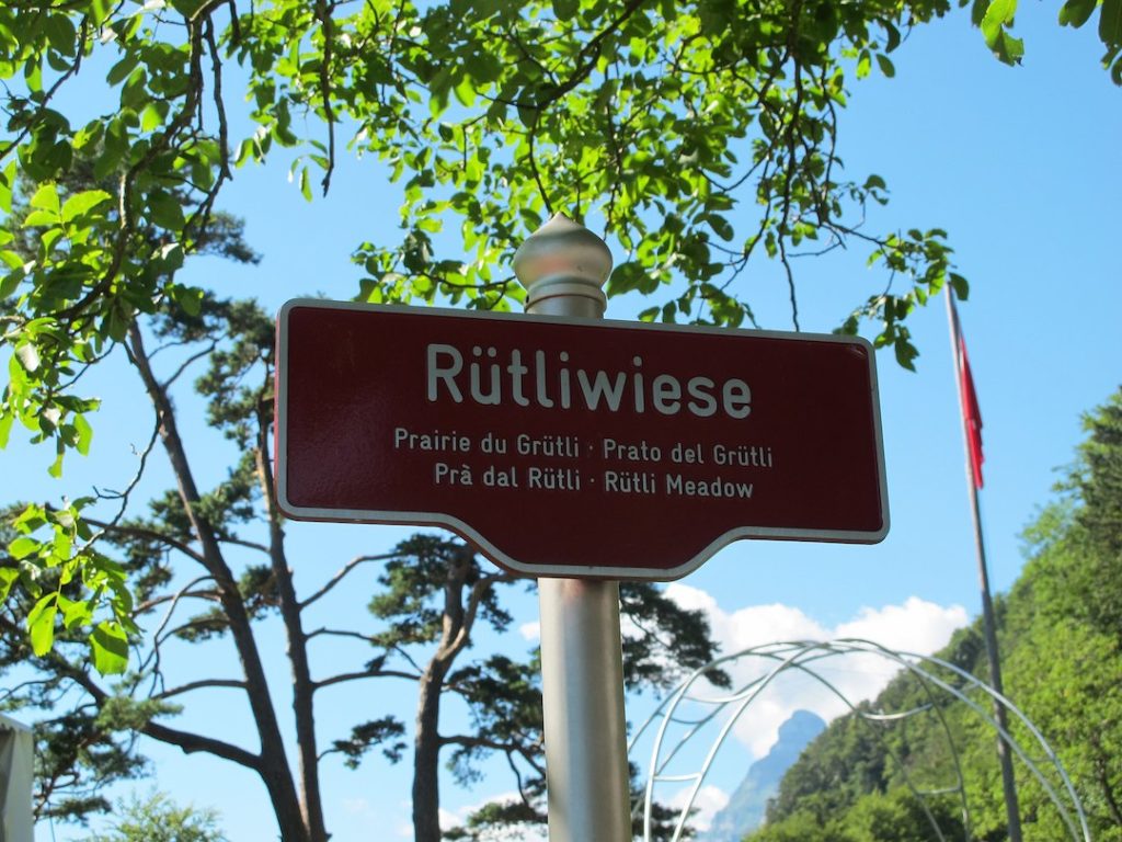 Знак места «Луг Рютли» на четырех национальных языках Швейцарии (немецком, французском, итальянском, ретороманском) и на английском. (DrHäxer)