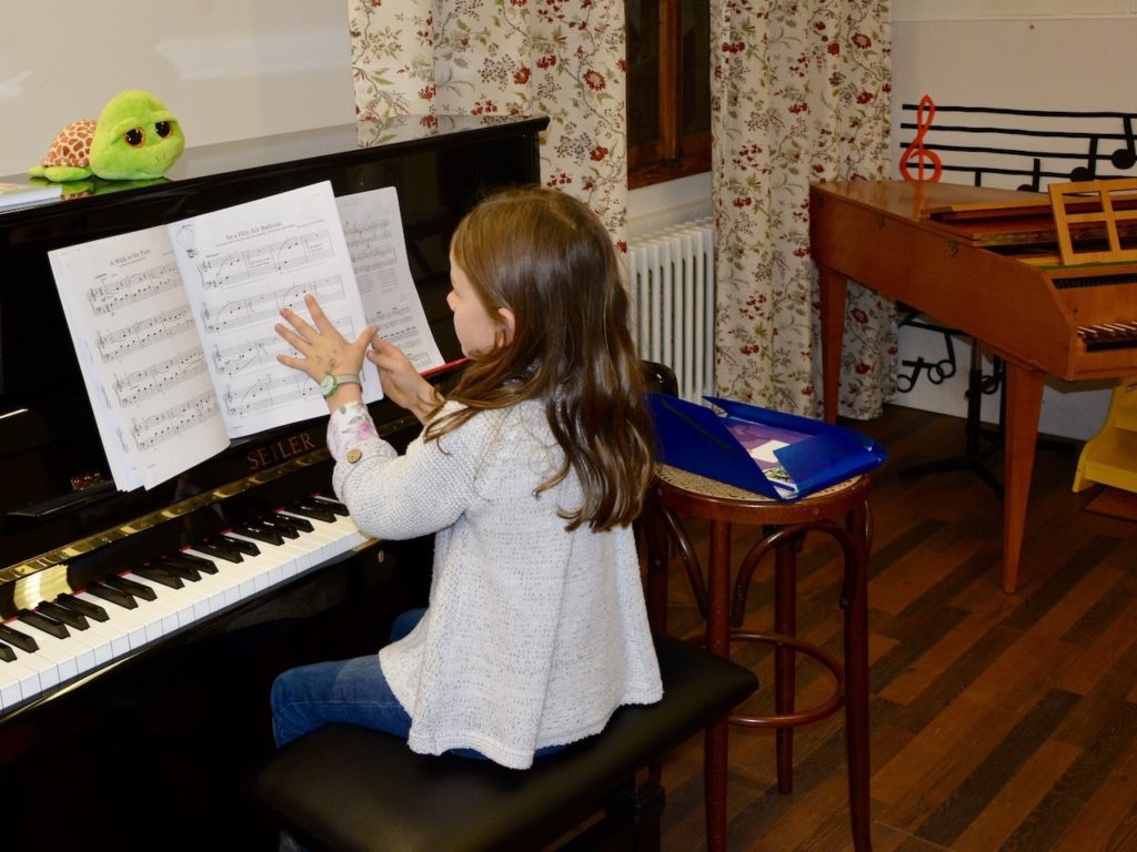 В школе музыки Елены Виноградовой маленькому ребёнку комфортно за большим фортепиано. (© schwingen.net)