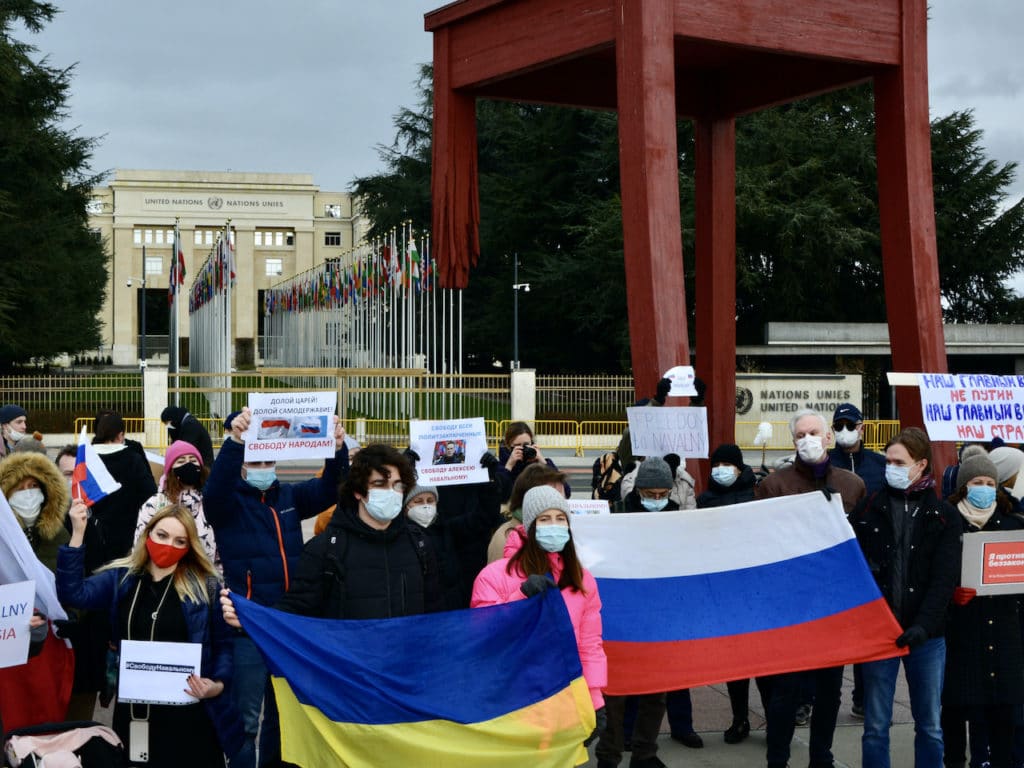 Люди пришли на женевскую площадь перед Дворцом Наций с флагами России, Беларуси, Украины. (© schwingen.net)