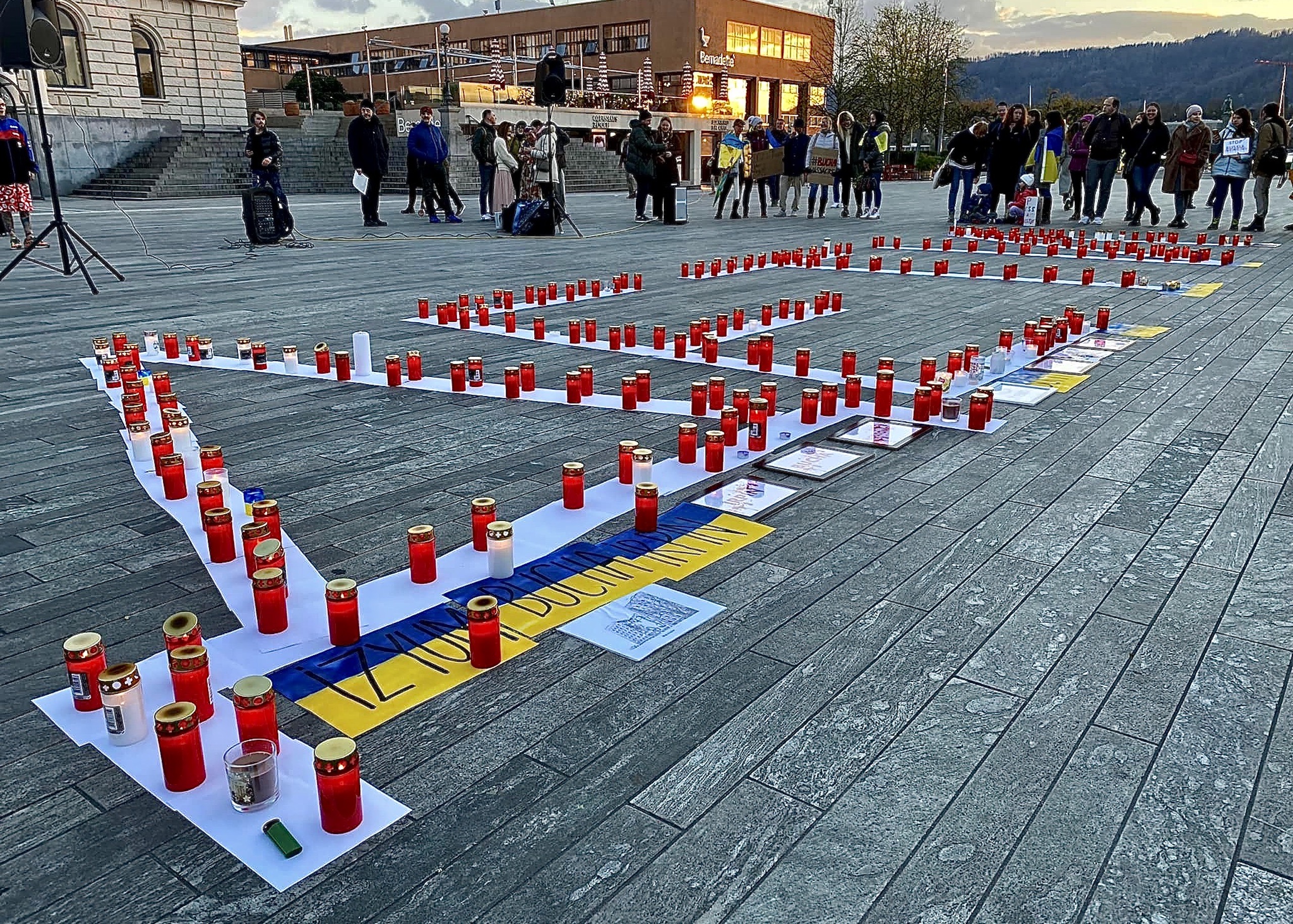 Горящие свечи вечером 9 апреля 2022 г. перед оперным театром Цюриха в память о невинно погибших в войне России против Украины. (© Lucky Ukraine)